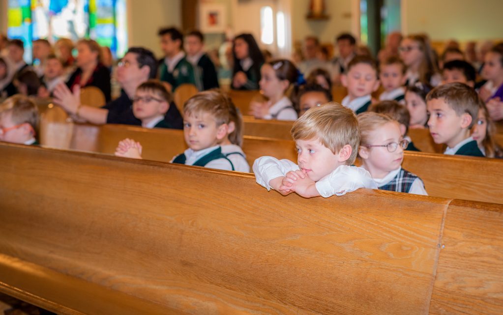 Student in Church kneeling at pew